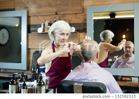 Female hairdresser working with client in barbershop Female hairdresser working with client in barbershop 132592313