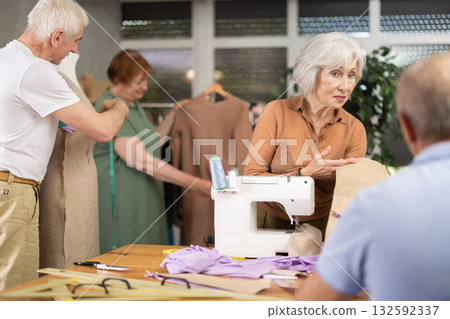 Woman and man discussing patterns with fabric in training sewing workshop Woman and man discussing patterns with fabric in training sewing workshop 132592337