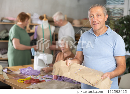 Elderly man with pattern at sewing master class 132592415