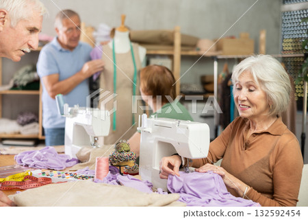 Elderly male teacher showing how to sew on mannequin Elderly male teacher showing how to sew on mannequin 132592454