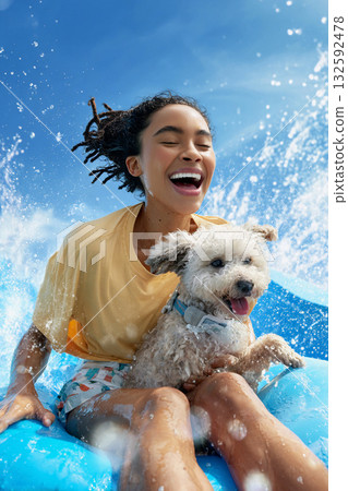 女孩和狗狗在水中嬉戲玩耍，笑容燦爛。 132592478