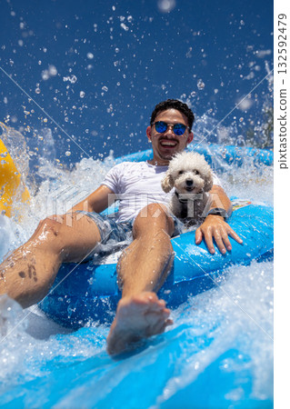 Man and dog sliding down a water slide Man and dog sliding down a water slide 132592479