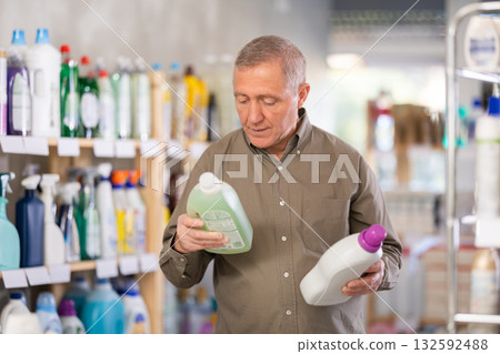 Mature man choosing a cleaning product Mature man choosing a cleaning product 132592488
