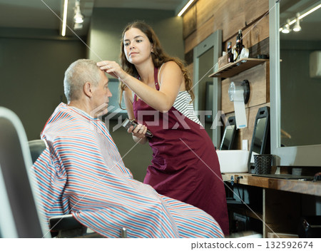 Hairdresser cutting hair of male client. Hairstylist serving client at barber shop Hairdresser cutting hair of male client. Hairstylist serving client at barber shop 132592674