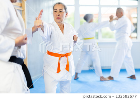 Senior karate practitioner engage in fierce fight oriental single combat Senior karate practitioner engage in fierce fight oriental single combat 132592677