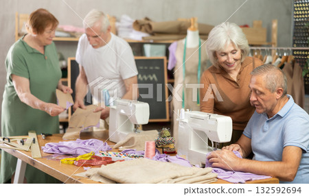 Elderly female showed group of elderly people how to sew on machine 132592694