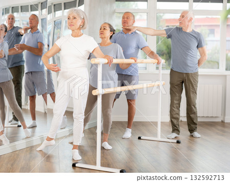 Male choreographer teaches elderly ballet lovers to keep their heads straight during ballet lesson Male choreographer teaches elderly ballet lovers to keep their heads straight during ballet lesson 132592713