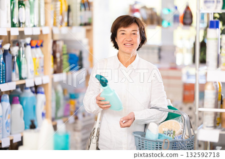 Elderly woman chooses household chemicals in store 132592718