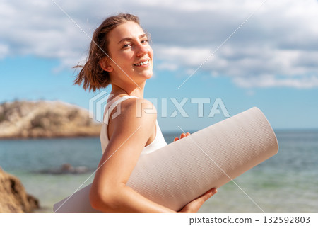 Portrait of smiling woman in sportswear holding 132592803