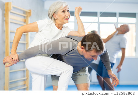 Old woman practicing self-defense techniques in pairs Old woman practicing self-defense techniques in pairs 132592908