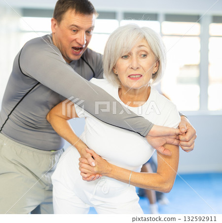 Old woman practicing self-defense techniques in pairs 132592911