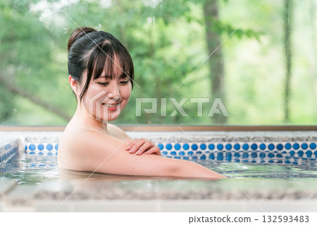 A woman bathing in a hot spring bath at a hot spring inn or private bath A woman bathing in a hot spring bath at a hot spring inn or private bath 132593483