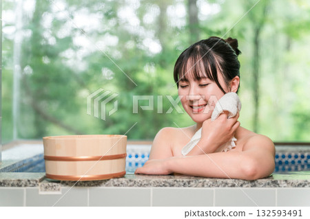 A woman bathing in a hot spring bath at a hot spring inn or private bath A woman bathing in a hot spring bath at a hot spring inn or private bath 132593491