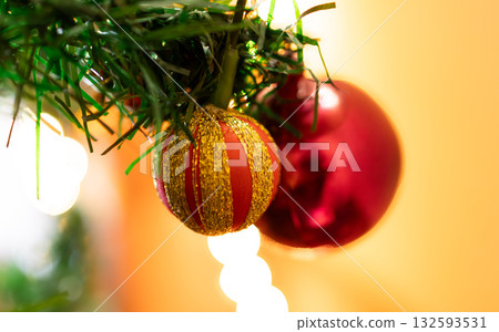 Glittering Christmas baubles and ornaments in red, gold and green, with warm light and bokeh blur. 132593531