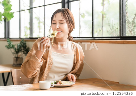 Young Asian woman eating pasta for lunch in a cafe 132594386