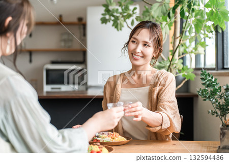 在女孩聚會上，年輕的亞洲女性用冷清酒杯喝日本清酒 132594486
