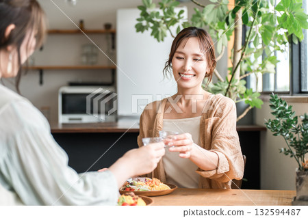 在女孩聚會上，年輕的亞洲女性用冷清酒杯喝日本清酒 132594487