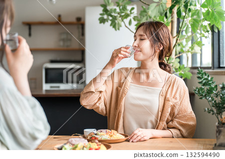 在女孩聚會上，年輕的亞洲女性用冷清酒杯喝日本清酒 132594490