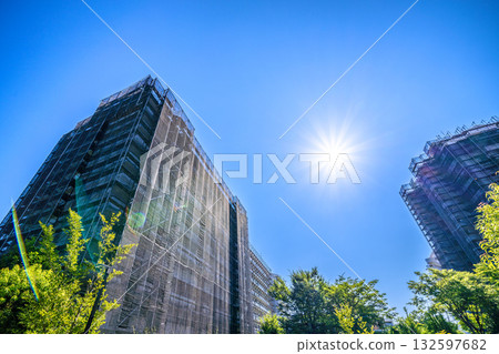 日本橫濱的城市景觀：重現昔日光彩……陽光下，一棟正在維修的公寓大樓。鷹架、防護網和衛星天線。 132597682