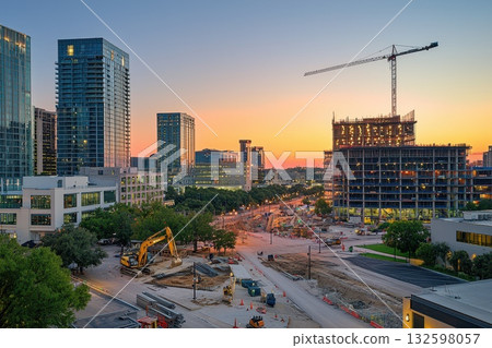 Urban Construction Site at Sunset with Cranes and Skyscrapers in a Bustling Cityscape 132598057