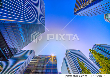 日本橫濱市街景中罕見的景象。太陽周圍環繞著一圈淡淡的神秘光環…新高島站前的摩天大樓景觀 日本橫濱市街景中罕見的景象。太陽周圍環繞著一圈淡淡的神秘光環…新高島站前的摩天大樓景觀 132598139