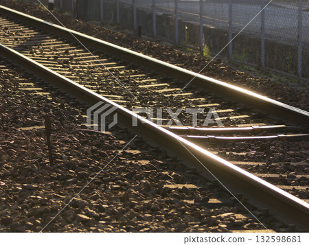 Railroad tracks reflecting the setting sun 132598681