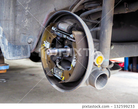 Close up of car rear drum brake assembly with wheel cylinder, brake shoes and axle Close up of car rear drum brake assembly with wheel cylinder, brake shoes and axle 132599233