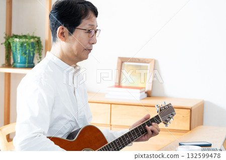 中年男子在客廳彈吉他 132599478