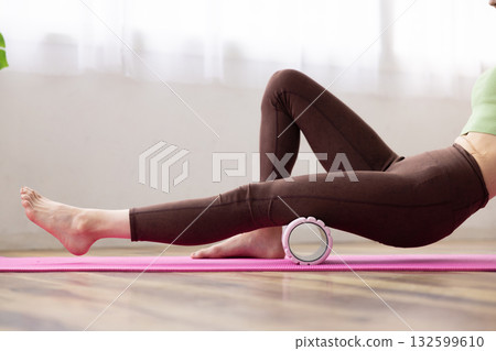 一位女士用泡沫軸按摩大腿。 132599610