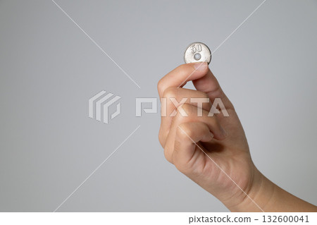 一隻孩子的手拿著一枚50日圓硬幣 132600041