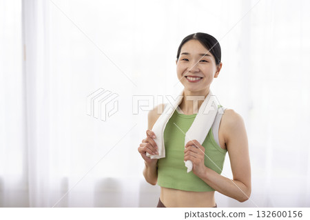 一位身穿瑜珈服、脖子上圍著毛巾的微笑女子 132600156