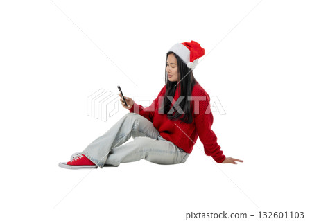 Woman in a Christmas hat uses her smartphone, isolated, PNG 132601103