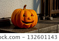 A jack-o-lantern sitting on the steps of a house 132601143