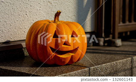 A jack-o-lantern sitting on the steps of a house A jack-o-lantern sitting on the steps of a house 132601143
