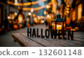 A wooden table with the word HALLOWEEN spelled out in black letters on it 132601148