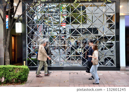 Pedestrians in front of a glass building on Ginza Namiki-dori 132601245
