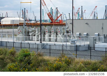 A GIS gas-insulated switchgear substation installed on Yumeshima Island near the Osaka-Kansai Expo site, with a crane in the distance A GIS gas-insulated switchgear substation installed on Yumeshima Island near the Osaka-Kansai Expo site, with a crane in the distance 132601536