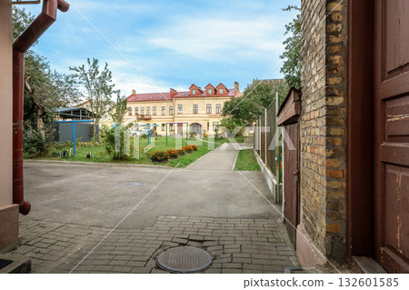 Old courtyard with paved walkway leading to historic residential building Old courtyard with paved walkway leading to historic residential building 132601585
