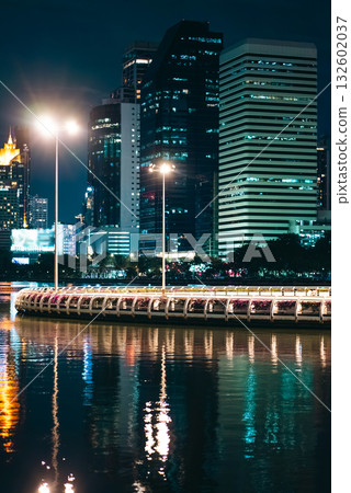 evening panorama of Bangkok city skyline with skyscrapers and Benchakitti park lake, vibrant cityscape view with reflections over pond water at dusk evening panorama of Bangkok city skyline with skyscrapers and Benchakitti park lake, vibrant cityscape view with reflections over pond water at dusk 132602037