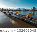 Golden Dragon Bridge over Han River in Da Nang at sunset, Iconic Vietnamese landmark spanning urban waterway with city skyline view 132602048