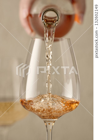 closeup of white wine pouring in glass closeup of white wine pouring in glass 132602149