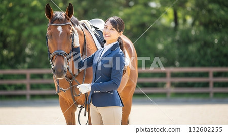 一位微笑的日本女子身著騎馬服，正在撫摸一匹馬。 132602255