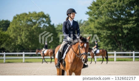 一位微笑的日本女子在馬術俱樂部的馬術場上騎馬。 132602257