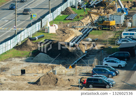 Construction site with underground pipeline installation and excavator 132602536
