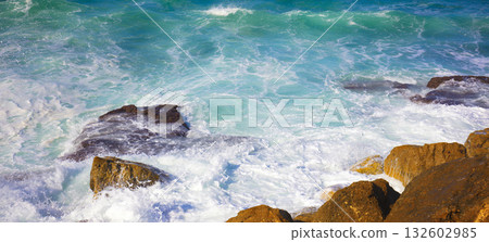 Waves roll onto the rocky shore. Horizontal banner 132602985