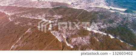 Ocean surf. Waves roll onto the shore. View from above. Horizontal banner 132603402