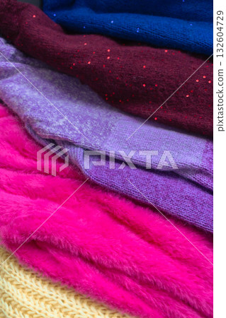 Stack of knitted sweaters. Different knitting patterns. Warm handmade clothes. Knitted sweater cardigans. Craft product concept. Winter fashion. Cozy woven clothing. Knitted fashion. Knitting hobby. Stack of knitted sweaters. Different knitting patterns. Warm handmade clothes. Knitted sweater cardigans. Craft product concept. Winter fashion. Cozy woven clothing. Knitted fashion. Knitting hobby. 132604729