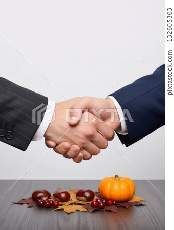 business handshake on a white background with autumn decor and a pumpkin business handshake on a white background with autumn decor and a pumpkin 132605303