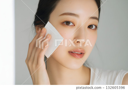 A young Japanese woman undergoing skin care. Close-up of skin care with cotton pads 132605396