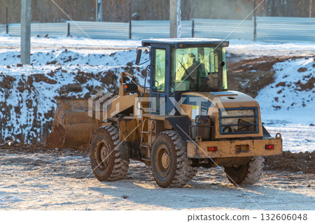 Yellow front loader wheeled tractor at a construction site at winter Yellow front loader wheeled tractor at a construction site at winter 132606048